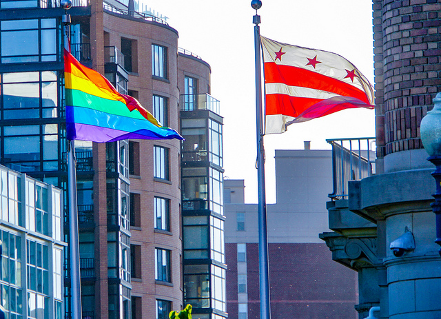 A Pride flag and the District of Columbia flag wave side by side