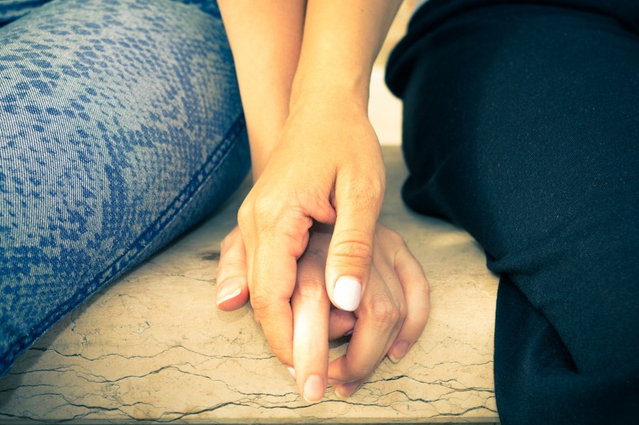 A closeup of two women's hands holding each other