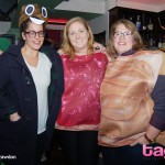 A woman wearing a poop emoji hat poses with women dressed in a peanut butter and jelly couples costume
