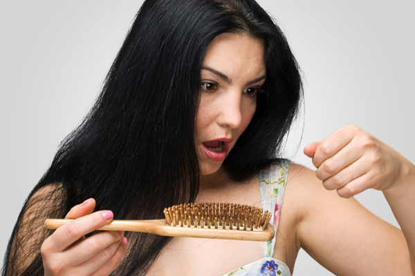 Woman pulling out hair out of her brush