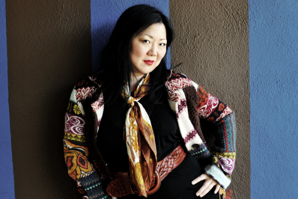 Margaret Cho standing in front of a blue background