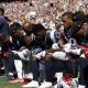 Several New England Patriots players kneel during the national anthem