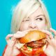 Blonde woman eating a burger