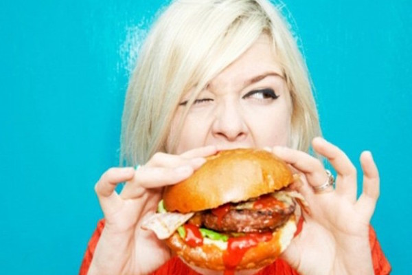 Blonde woman eating a burger