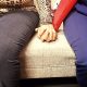 Two women sitting on a sofa holding hands