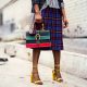 Woman standing in skirt and fashionable purse