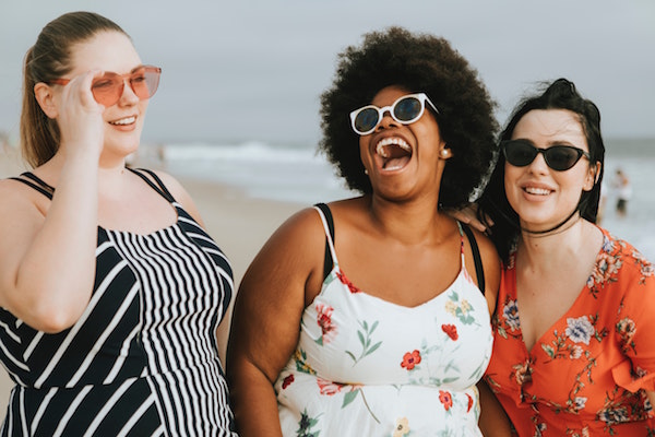 Three women at the beach laughing