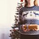 Woman in festive sweater holding a Christmas gift