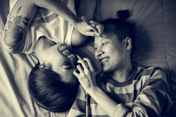 Asian Lesbian couple laughing on the bed