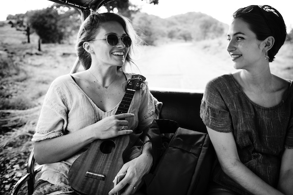 Two women smiling and sitting next to one another