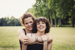 Two white women smiling and embracing