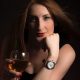 Woman sipping wine with a rolex watch on