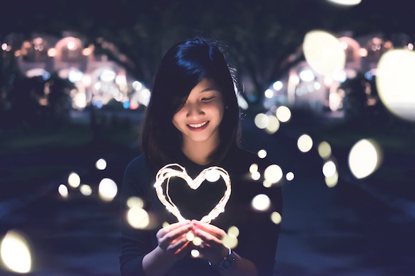 Woman holding lit up heart