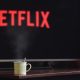 Netflix on TV with coffee mug on table