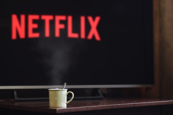 Netflix on TV with coffee mug on table