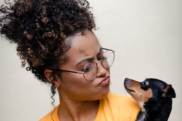 Woman of color holding short hair dog