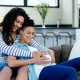 Woman sitting on sofa with pregnant partner