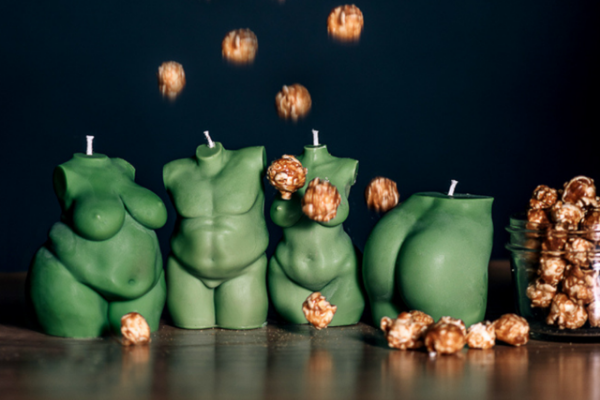 four green body shaped candles