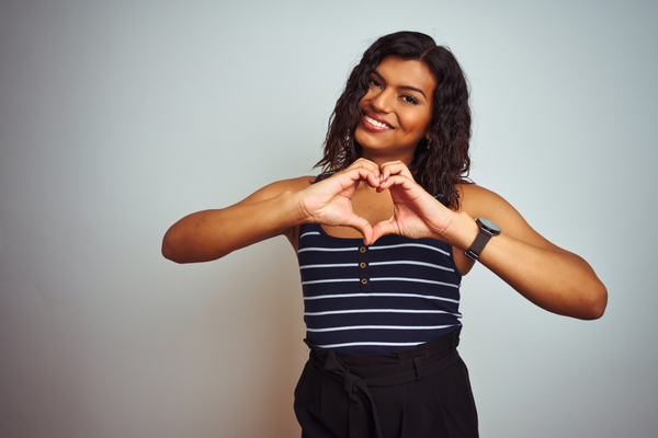 trans woman of color making a heart with her hands