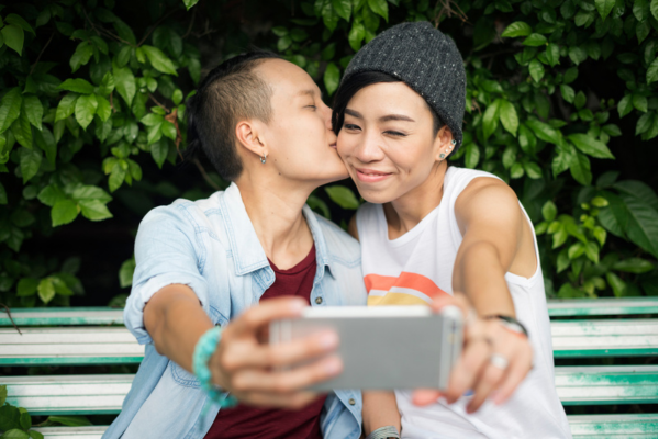 asian lesbian couple taking a selfie with a phone