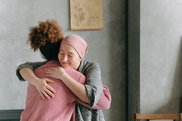 woman hugging cancer survivor