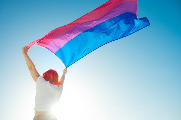woman with red hair with bi pride flag