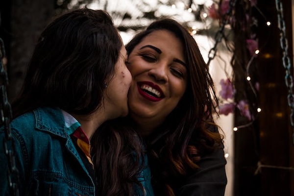 Lesbian couple smiling and kissing