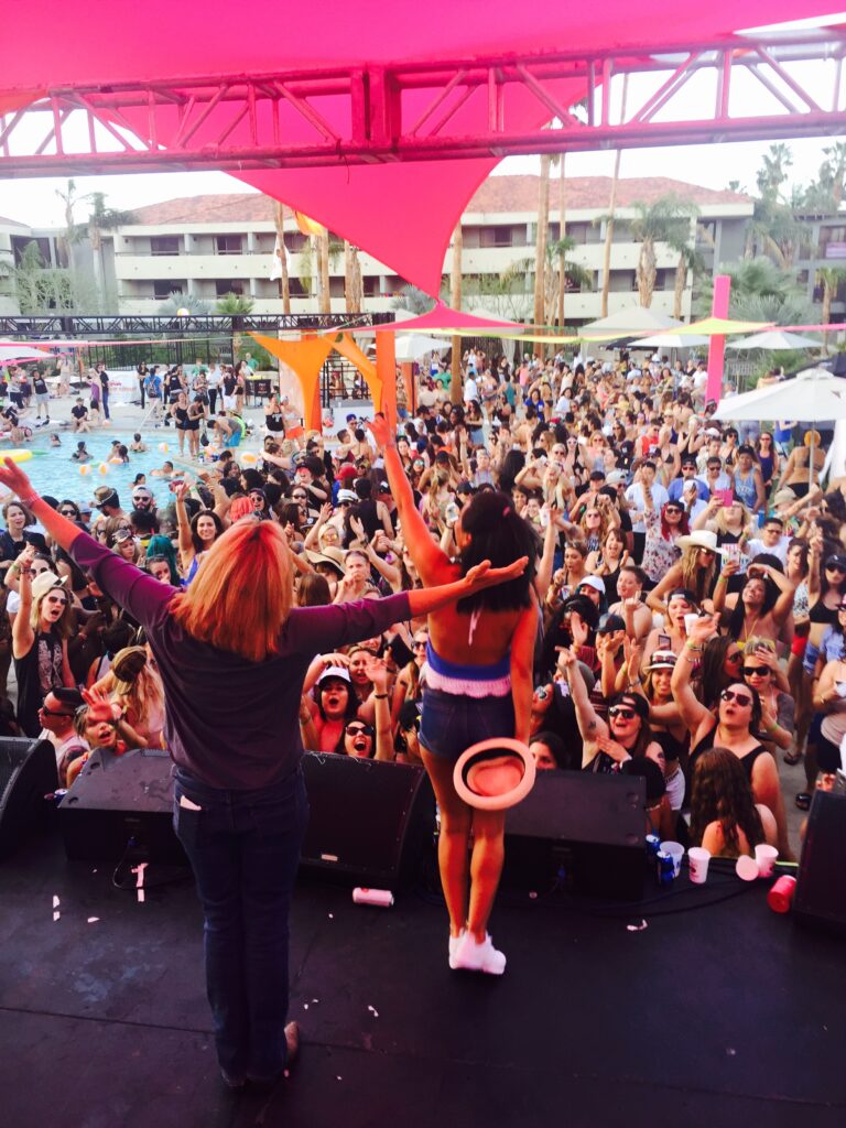 Mariah stands on stage in front of a crowd of attendees during one of the many events.