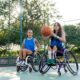 Two women in wheelchairs play basketball together.