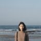 A woman stands before the ocean on a chilly day in Taiwan.