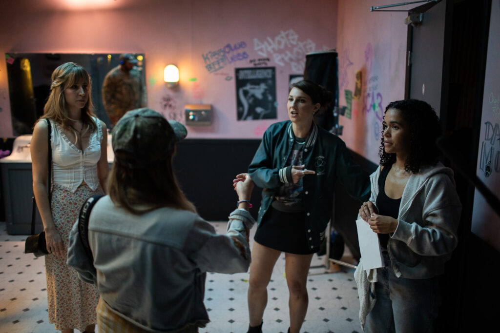 Center, Director Jasia Ka. From Left, Actors Ann Marie Wilding, Caroline Klidonas, Nicole Daniels all pose in a bathroom on the set of Stalling.