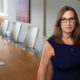 LGBTQ+ candidate for Congress Sarah McBride poses in a conference room, leaning on the conference table.