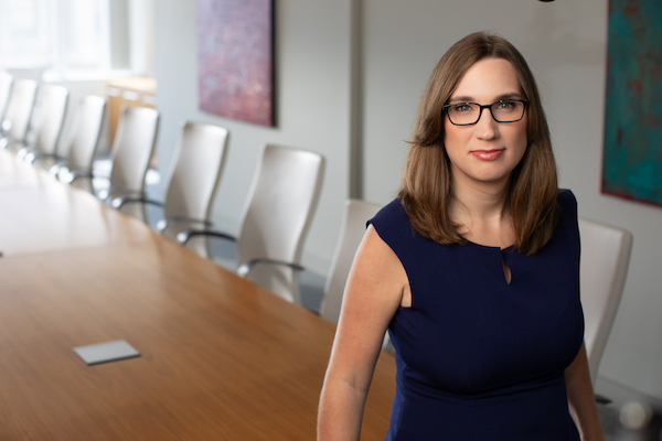 LGBTQ+ candidate for Congress Sarah McBride poses in a conference room, leaning on the conference table.