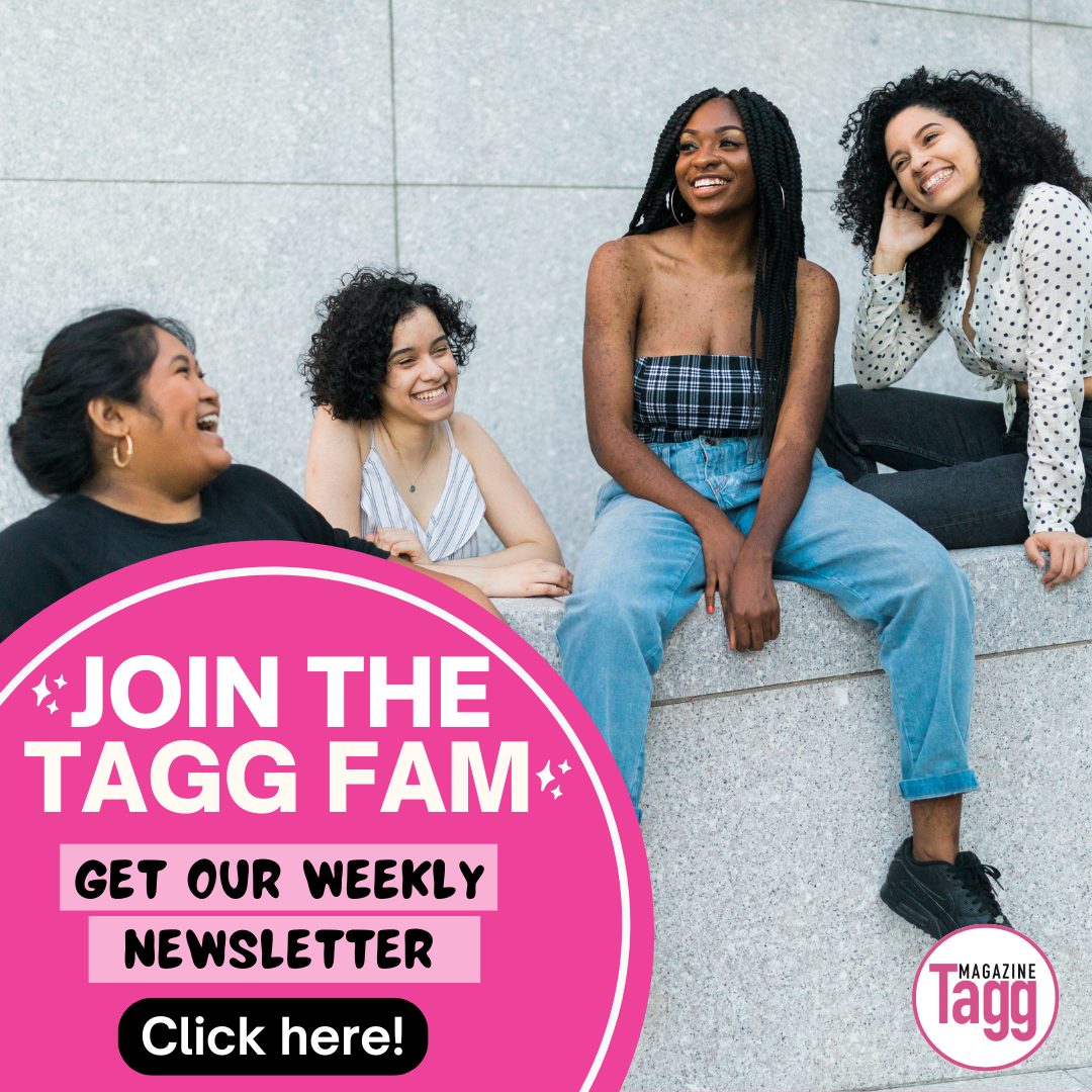 Four women sit and stand together around a stone ledge, laughing and talking.