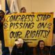 A group of transgender advocates hold a sign that reads, "Congress stop pissing on our rights!"