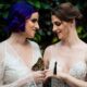 Zooey Zephyr and Erin Reed pose in white wedding dresses as butterflies perch on their fingers.