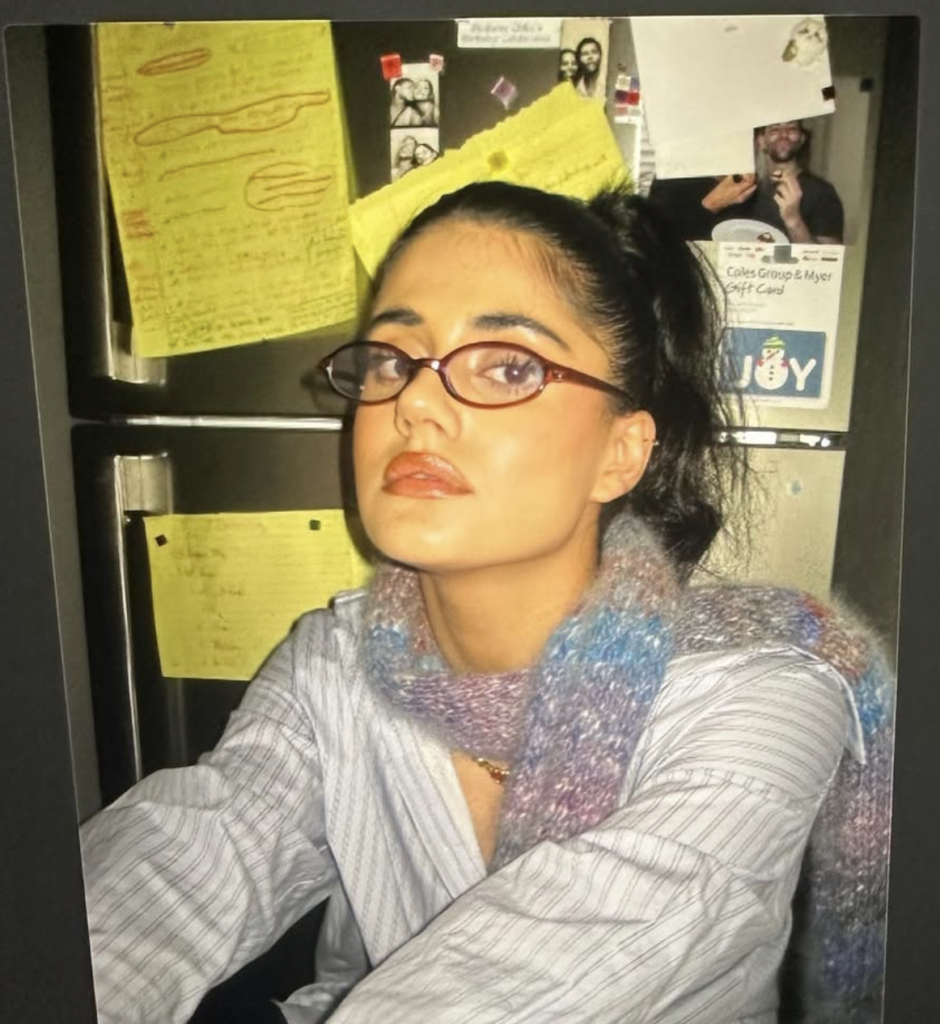 Ayesha Madon takes a selfie as she wears a striped shirt and a fuzzy scarp.