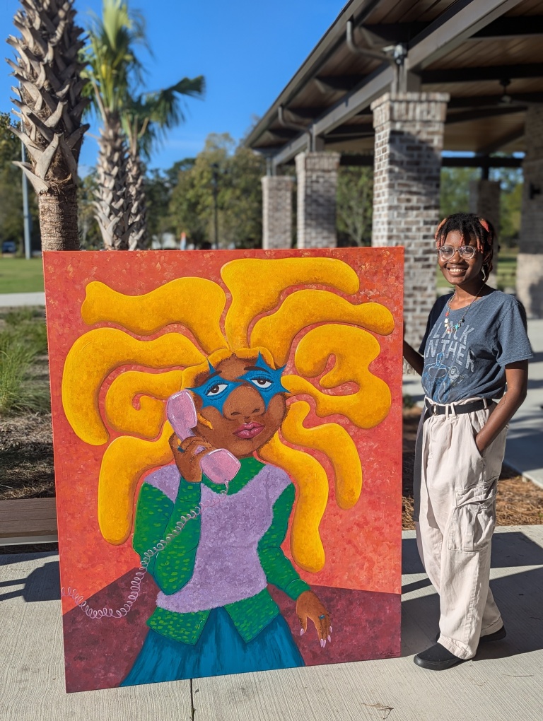 A large painting shows a Black person with long yellow hair popping out of their head as they hold a purple phone to their ear. The artist poses beside the painting.